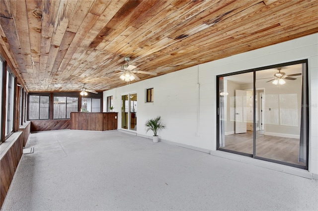 unfurnished sunroom with wood ceiling and ceiling fan