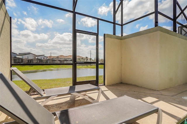 unfurnished sunroom featuring a water view and a residential view