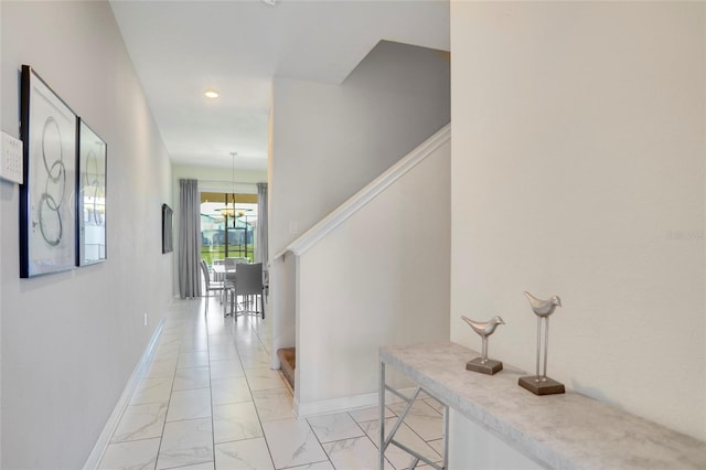 hallway with marble finish floor, recessed lighting, and baseboards