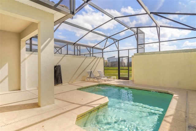 outdoor pool with glass enclosure and a patio