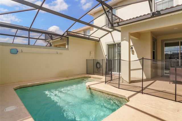 pool featuring glass enclosure and a patio area