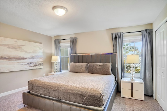 carpeted bedroom featuring a closet and baseboards