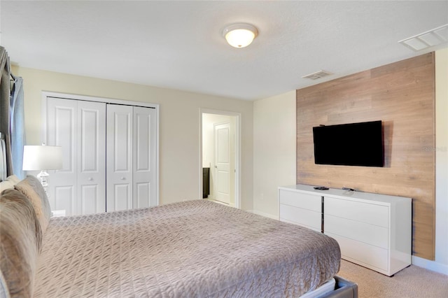 bedroom with baseboards, visible vents, a closet, and light colored carpet