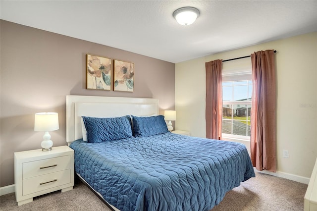 bedroom with light colored carpet and baseboards