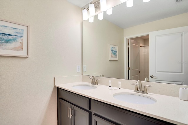 bathroom with visible vents, a sink, and double vanity