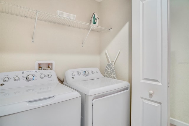 clothes washing area featuring independent washer and dryer