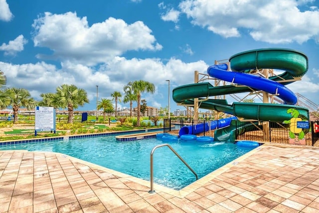view of pool featuring a water slide and fence