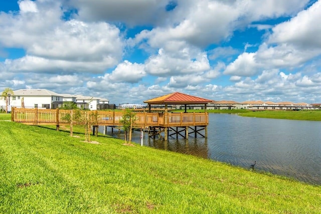 view of dock featuring a gazebo, a lawn, a water view, and a residential view