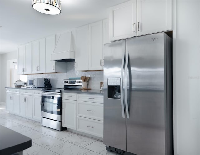 kitchen featuring white cabinetry, marble finish floor, premium range hood, and appliances with stainless steel finishes