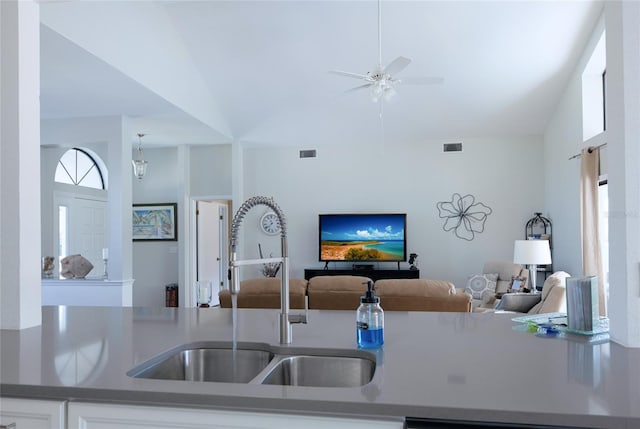 kitchen featuring open floor plan, dark countertops, a sink, and visible vents