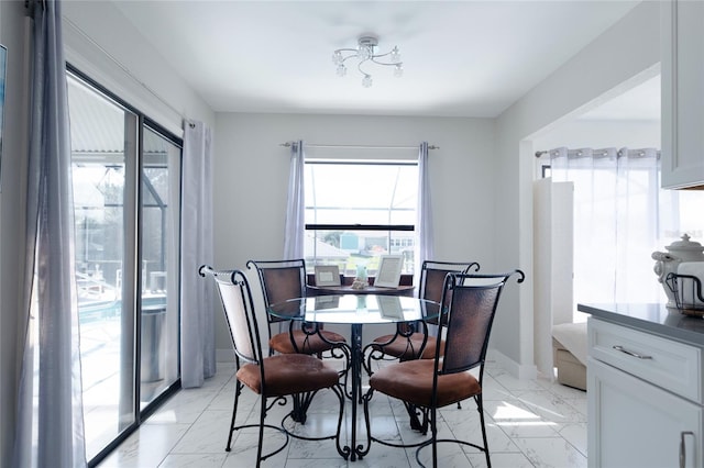 dining space with marble finish floor and baseboards