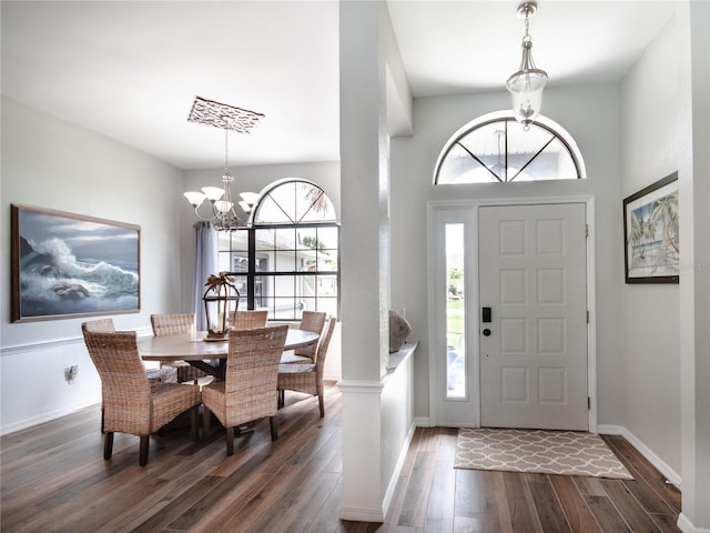 foyer entrance featuring baseboards, dark wood finished floors, and a notable chandelier