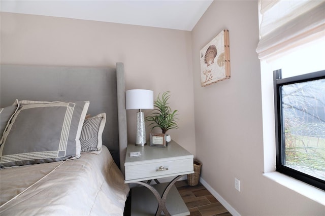 bedroom with baseboards and wood finished floors