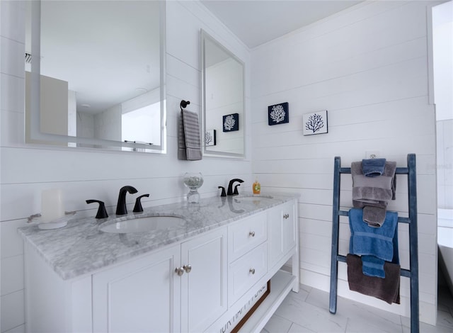 bathroom featuring double vanity, marble finish floor, and a sink