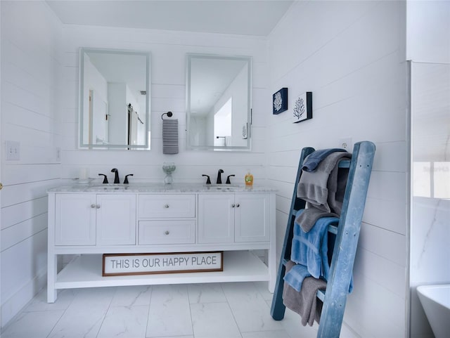 bathroom featuring marble finish floor, double vanity, plenty of natural light, and a sink