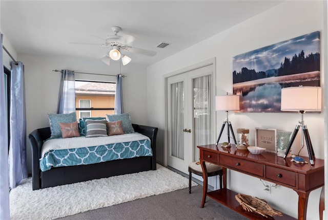 carpeted bedroom with ceiling fan, french doors, and visible vents