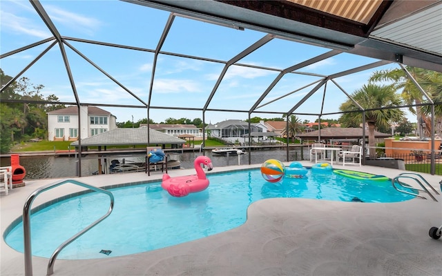 outdoor pool with a water view, glass enclosure, a patio area, and a residential view