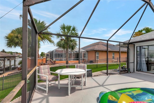 view of patio / terrace with a lanai and fence