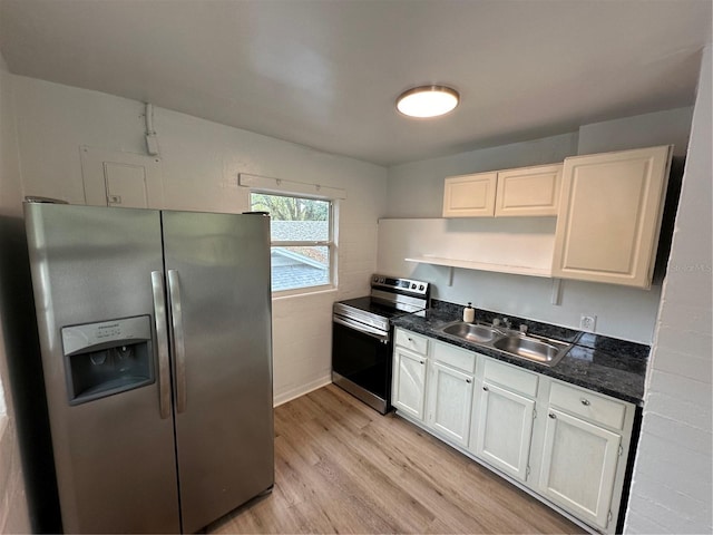 kitchen with light wood-style floors, appliances with stainless steel finishes, white cabinets, and a sink