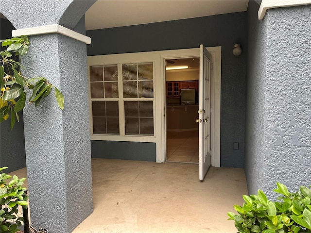 doorway to property featuring stucco siding