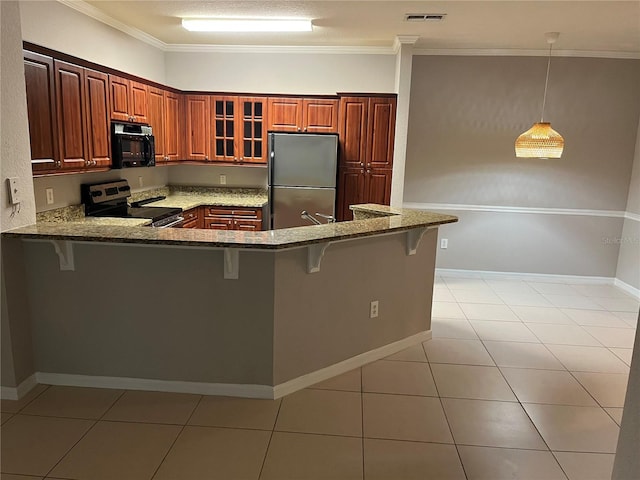 kitchen featuring a breakfast bar, visible vents, appliances with stainless steel finishes, glass insert cabinets, and a peninsula