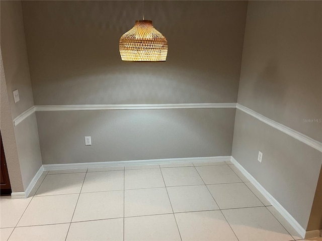 unfurnished dining area with baseboards and light tile patterned floors