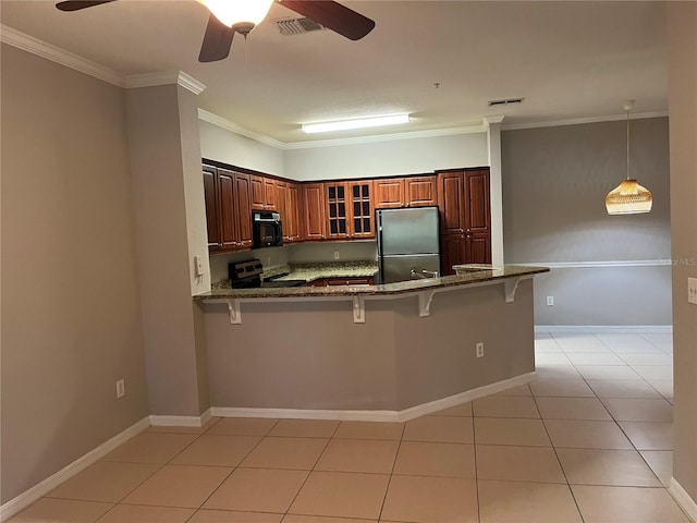 kitchen featuring appliances with stainless steel finishes, brown cabinetry, glass insert cabinets, a peninsula, and a kitchen breakfast bar