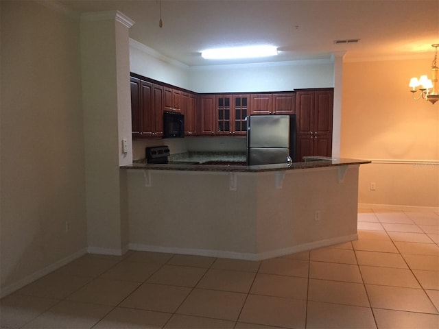 kitchen with dark countertops, appliances with stainless steel finishes, a breakfast bar area, a peninsula, and crown molding