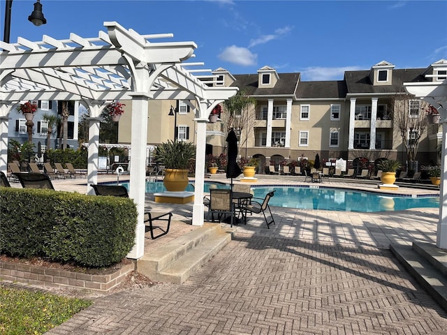 community pool featuring a patio area, a residential view, and a pergola