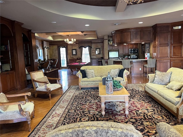 living area with a tray ceiling, recessed lighting, visible vents, wood finished floors, and billiards