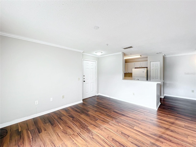 unfurnished living room featuring baseboards, visible vents, dark wood finished floors, and crown molding