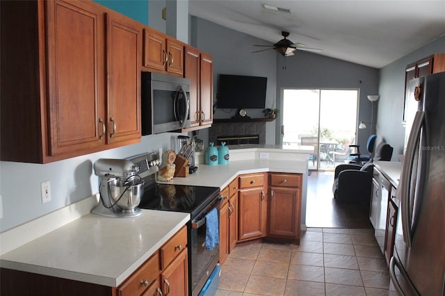 kitchen with visible vents, vaulted ceiling, light countertops, appliances with stainless steel finishes, and brown cabinets