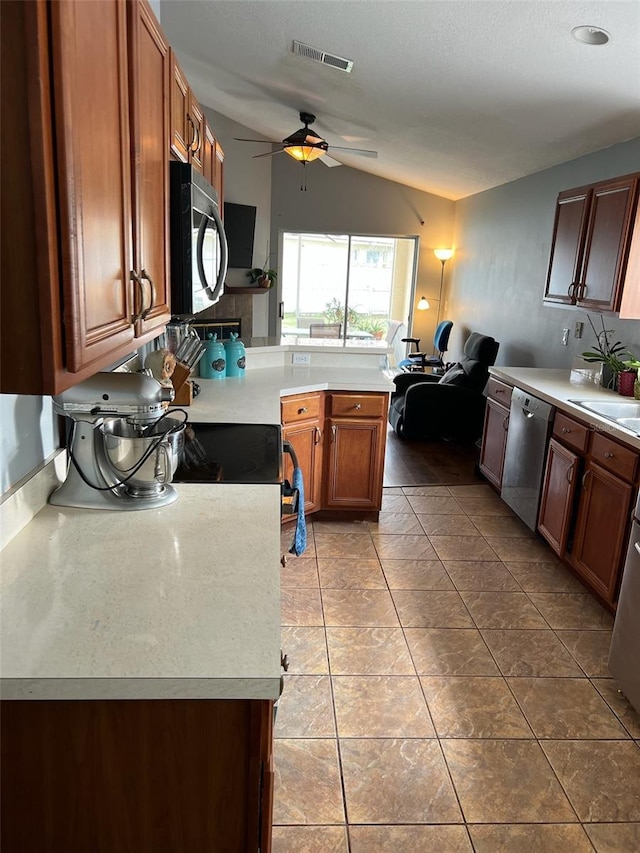 kitchen featuring brown cabinetry, light countertops, visible vents, and stainless steel dishwasher