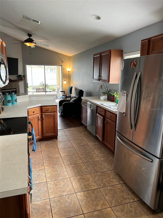 kitchen with visible vents, brown cabinetry, stainless steel appliances, light countertops, and light tile patterned flooring