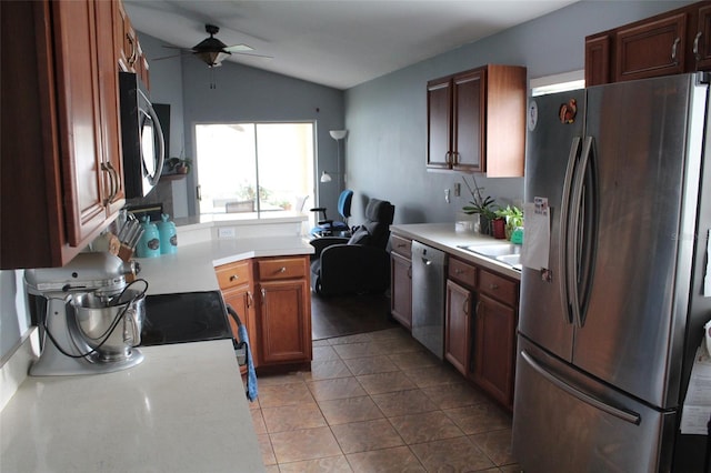 kitchen featuring a ceiling fan, vaulted ceiling, stainless steel appliances, light countertops, and light tile patterned flooring