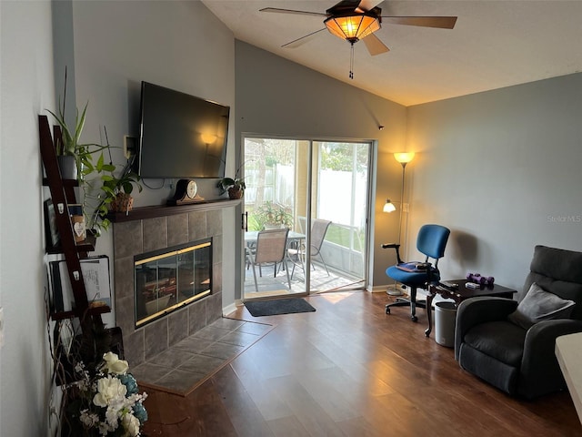 living room featuring dark wood finished floors, vaulted ceiling, a fireplace, and ceiling fan