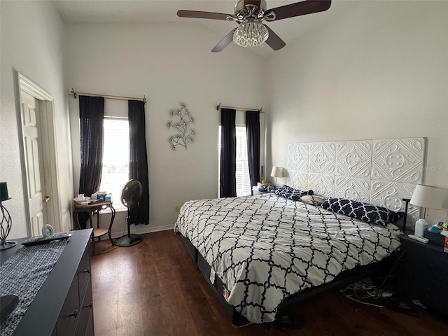 bedroom with lofted ceiling, baseboards, a ceiling fan, and dark wood-type flooring