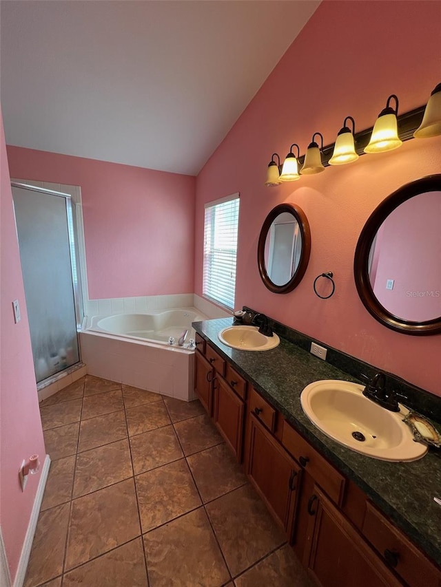 full bathroom featuring lofted ceiling, a sink, a bath, and tile patterned floors