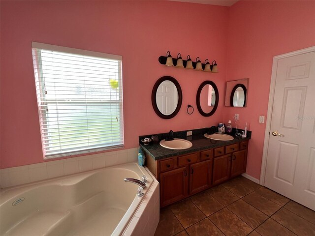 full bathroom featuring double vanity, tile patterned flooring, a sink, and a bath