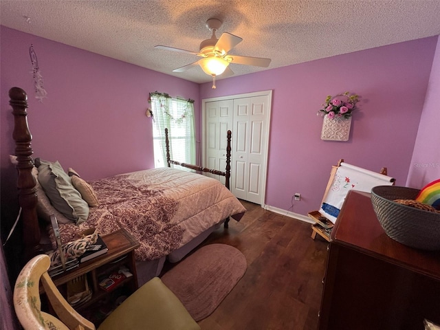 bedroom featuring a textured ceiling, dark wood-style flooring, a ceiling fan, baseboards, and a closet