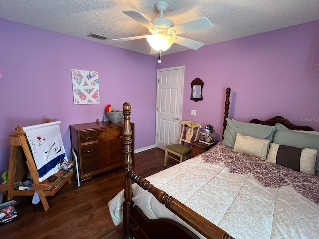 bedroom featuring ceiling fan, a textured ceiling, visible vents, and dark wood-style flooring