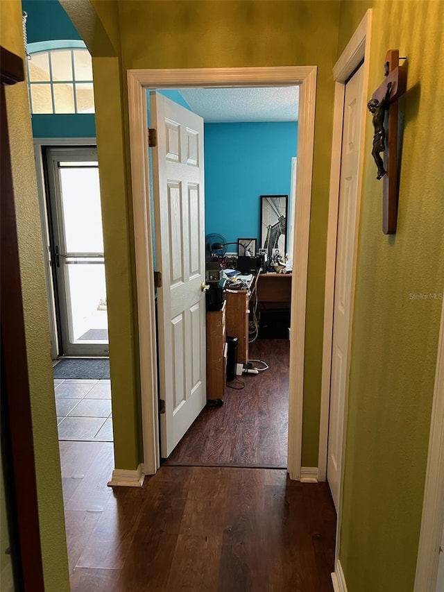 hall featuring dark wood-style floors and baseboards