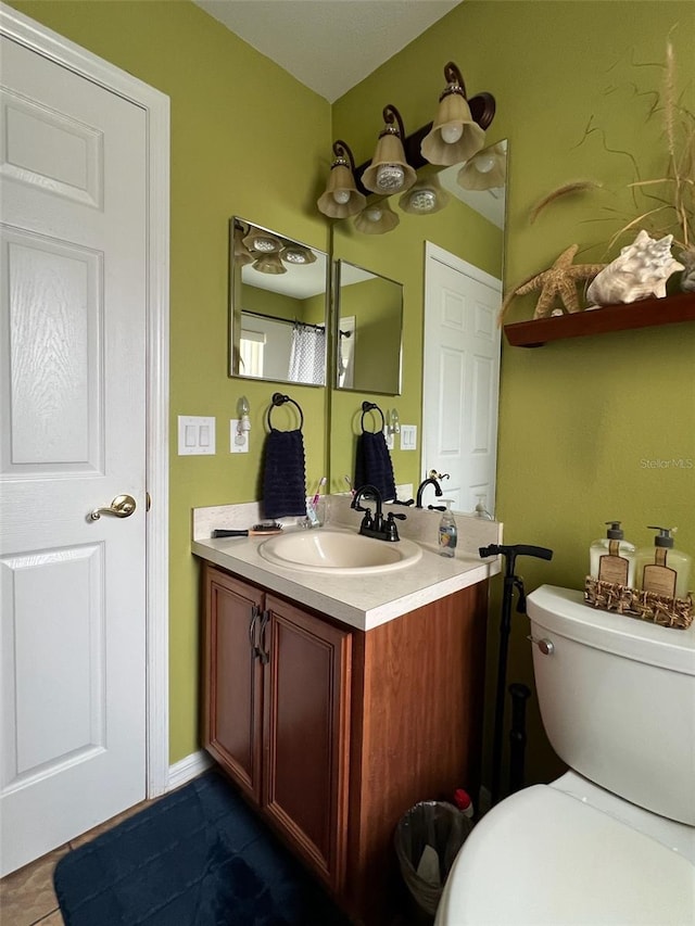 bathroom featuring toilet, tile patterned flooring, and vanity