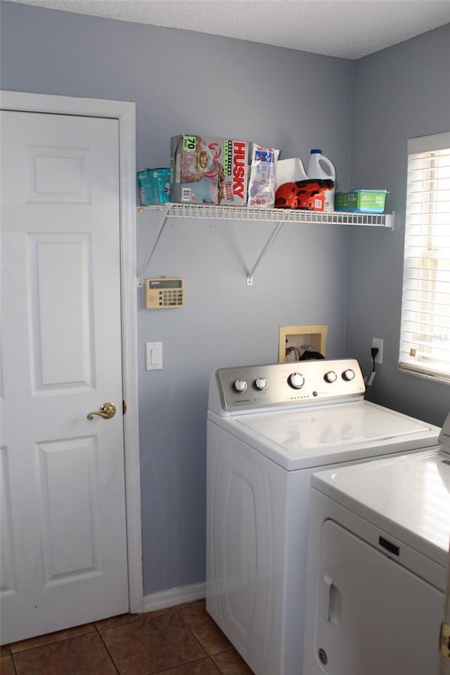 laundry room with washer and clothes dryer, a textured ceiling, dark tile patterned flooring, laundry area, and baseboards