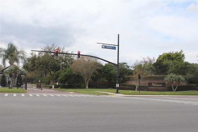 view of street with sidewalks, traffic lights, traffic signs, and curbs