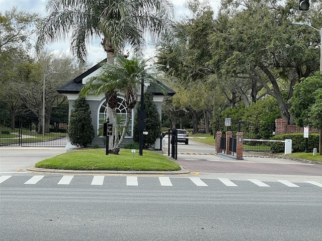 view of property's community featuring a gate and a lawn