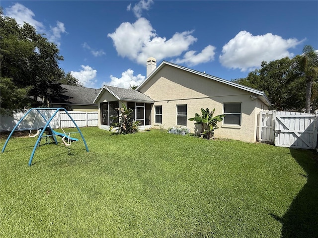 536 Dunoon St, Ocoee, FL 34761 - rear view of house featuring a playground, a gate, a sunroom, a fenced backyard, and a chimney