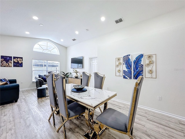 dining room featuring lofted ceiling, visible vents, light wood-style flooring, and baseboards