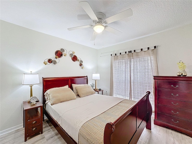 bedroom with a textured ceiling, ceiling fan, light wood finished floors, and baseboards