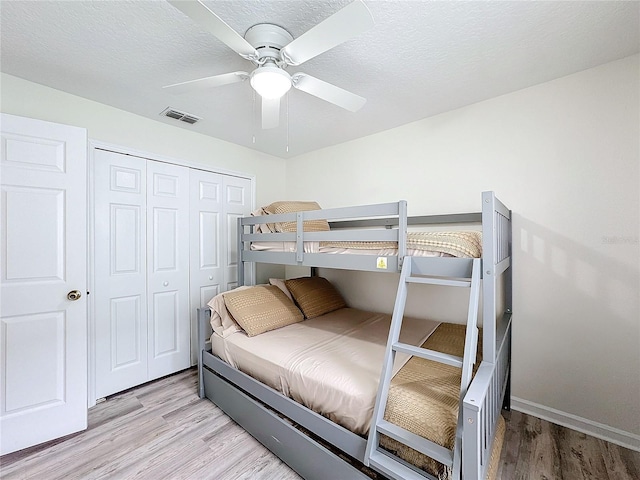 bedroom with a textured ceiling, visible vents, and light wood-style floors